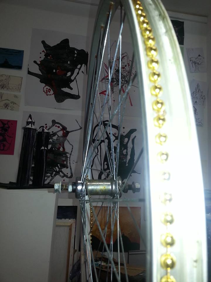 A photo of my bicycle wheel sculpture with some of my other work in the background.
