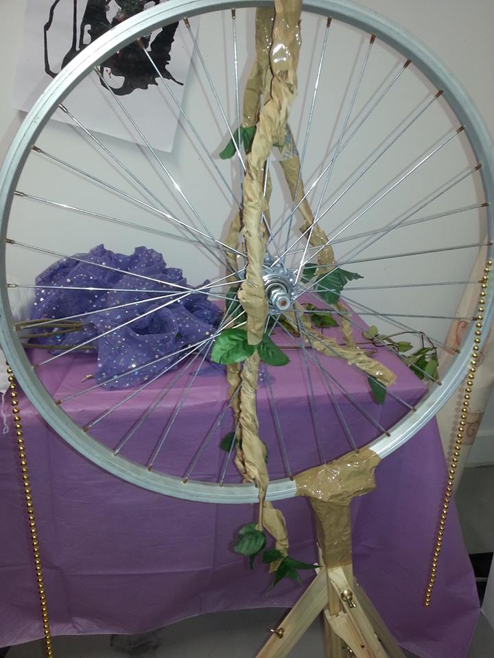 Artificial branches draped over the bicycle wheel.